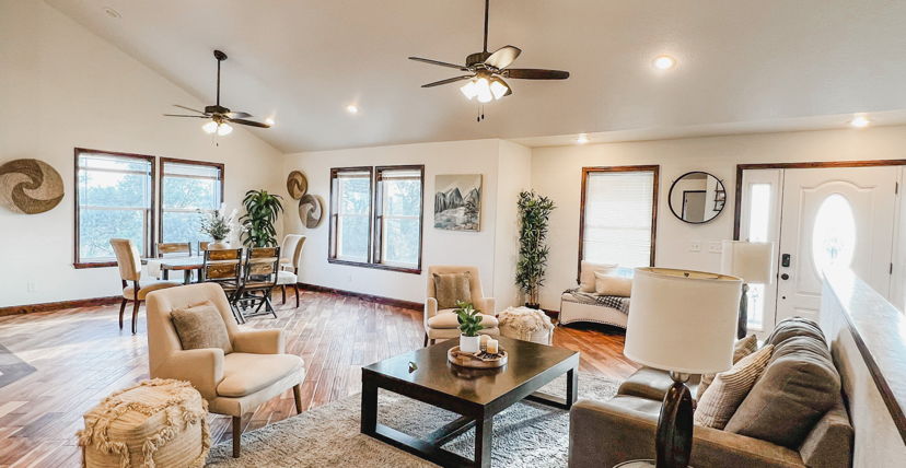 hardwood floored living room featuring natural light and a ceiling fan