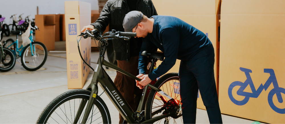 Upway mechanic and customer at NYC Garage Sale event with Aventon ebike