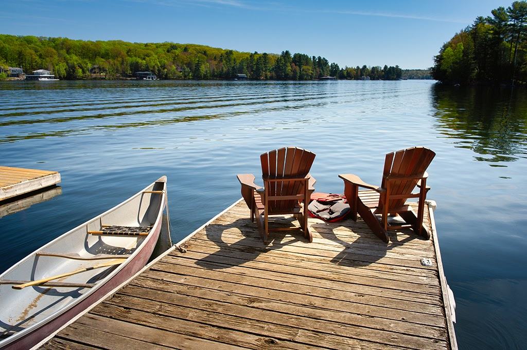 Two chairs on a dock overlooking a lake