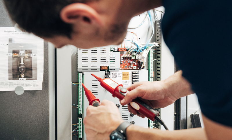 Elektrofachmann der Firma Epple bei der Prüfung von Schaltkreisen