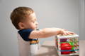 Little boy playing with his Montessori Shape Blocks Cube.