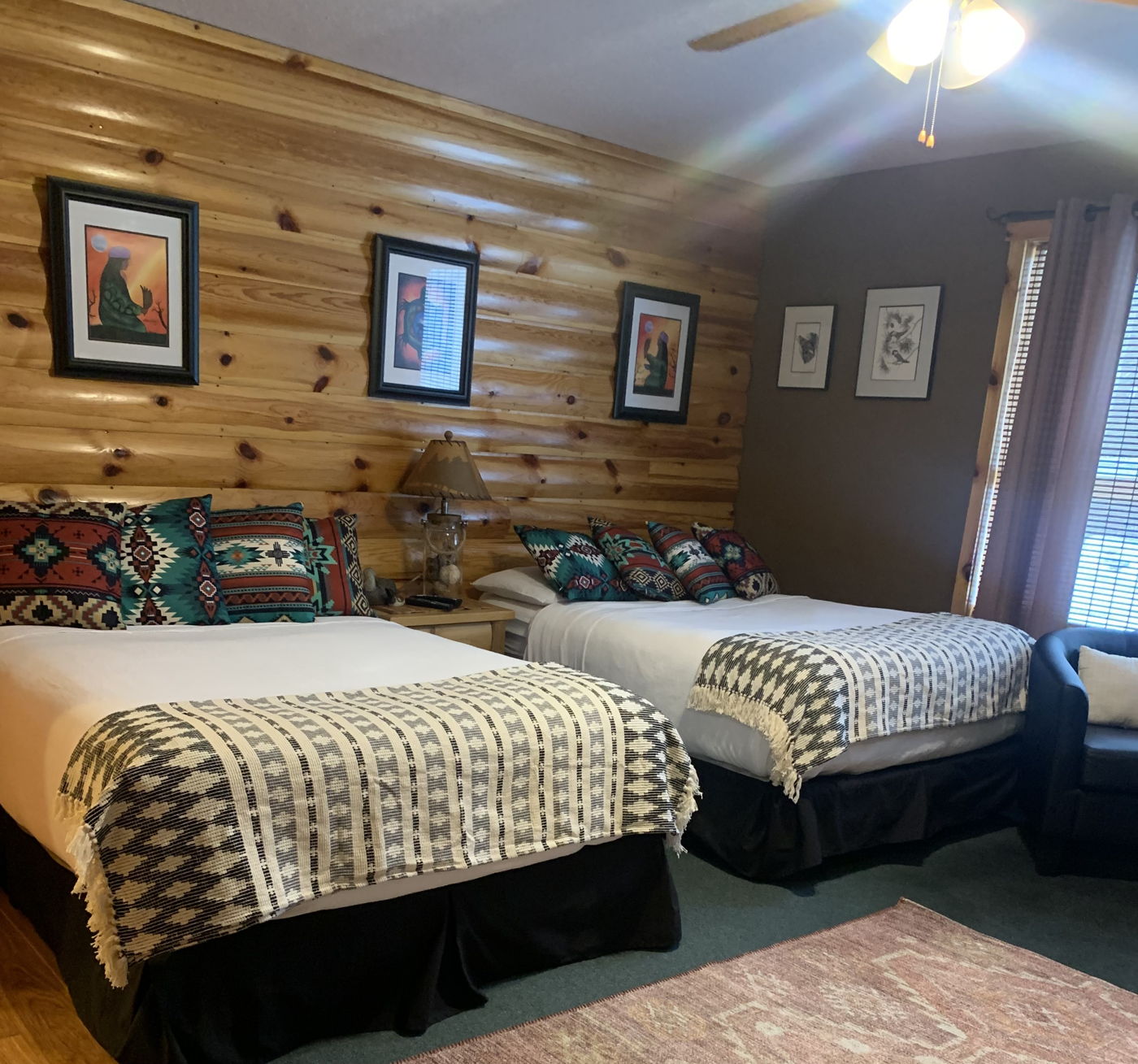 Cabin bedroom with two beds and knotty pine walls at Muskie Bay Resort