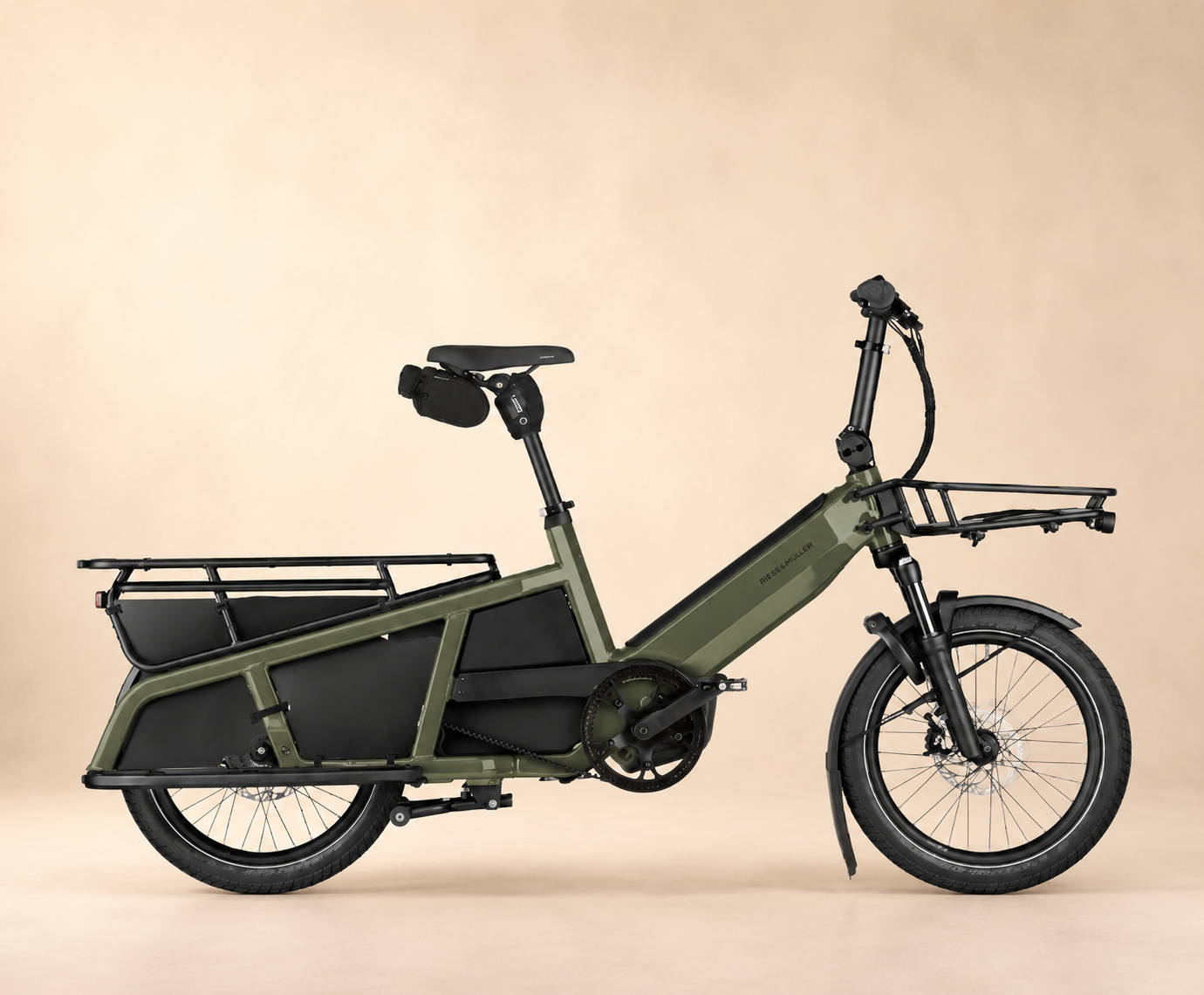 Riese & Müller elektrische cargofiets met lage instap, voordrager en ruime achterdrager op een milde studioachtergrond.