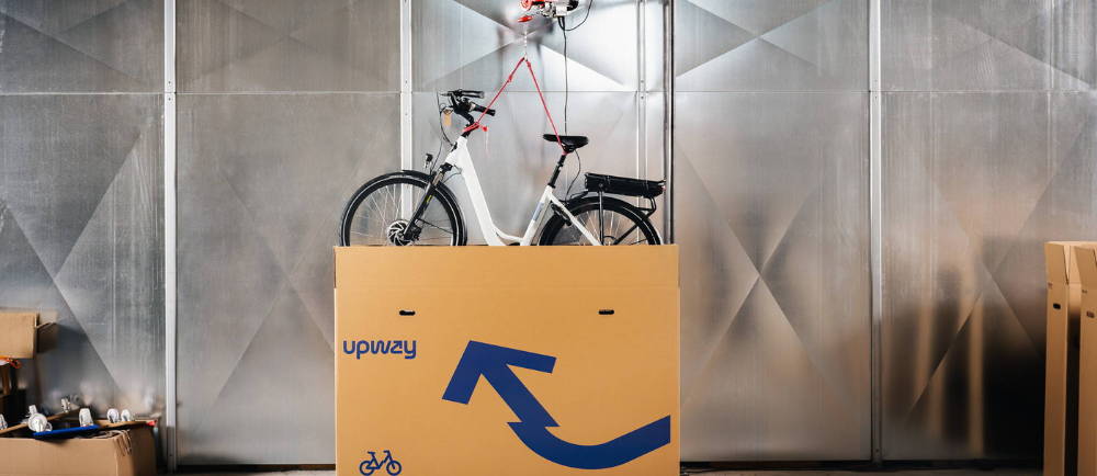 Electric bike lowered into Upway shipping box