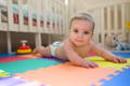 Baby playing on a floor.