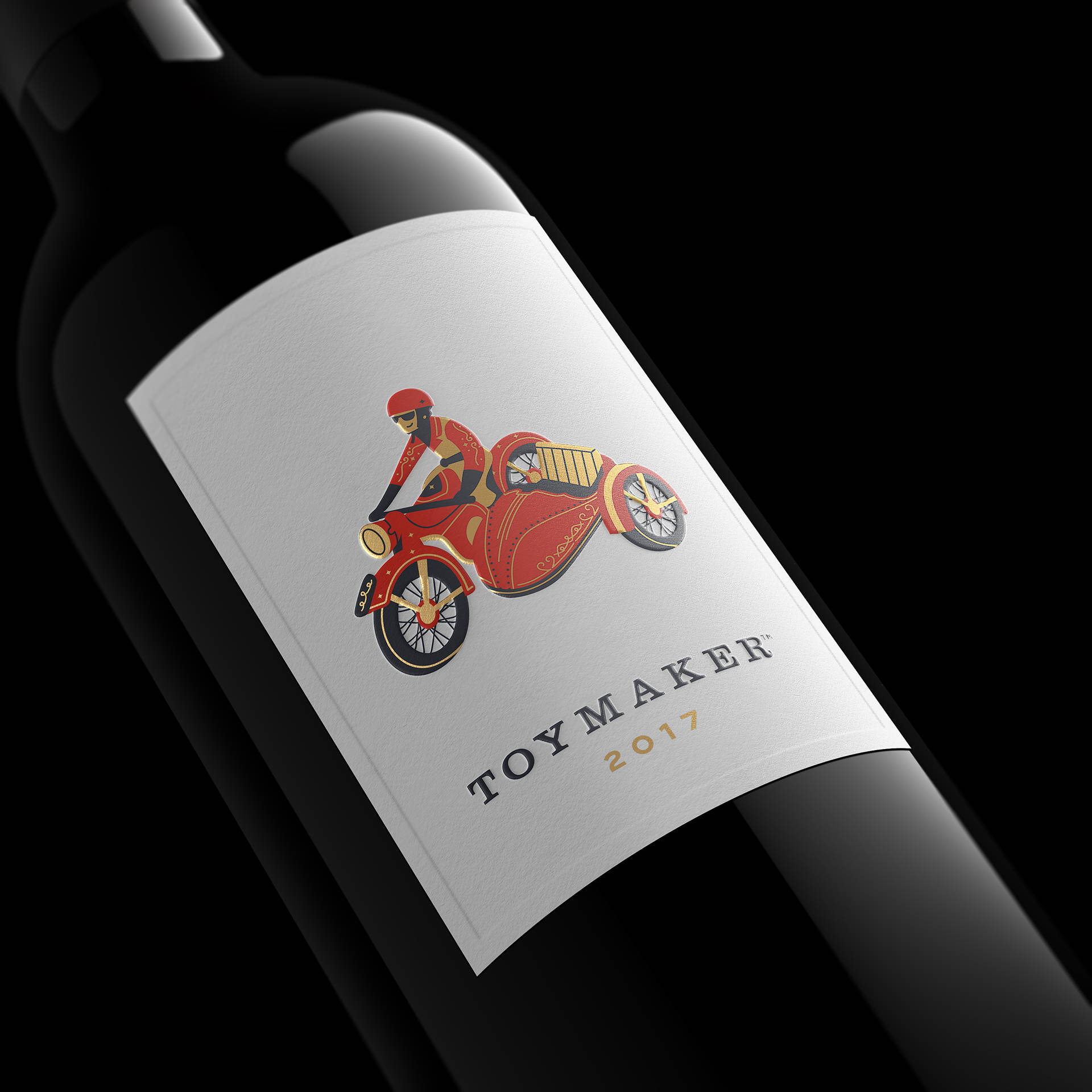 Red wine bottle with motorcycle and side car toy character with the words ToyMaker and 2017