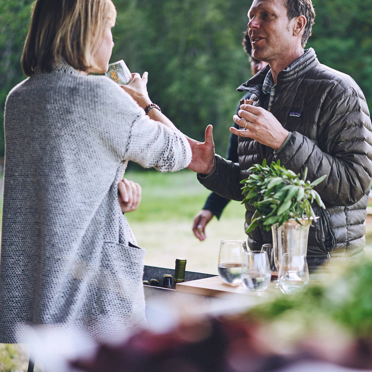 Dinner guests talking & drinking at farm-to-table dinner hosted by Stick & Ball