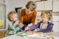 Preschool teacher painting with two toddlers. 