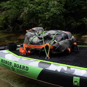 The backpack is tied to the paddleboard’s bungee cord