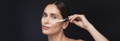 Woman applying serum on her face