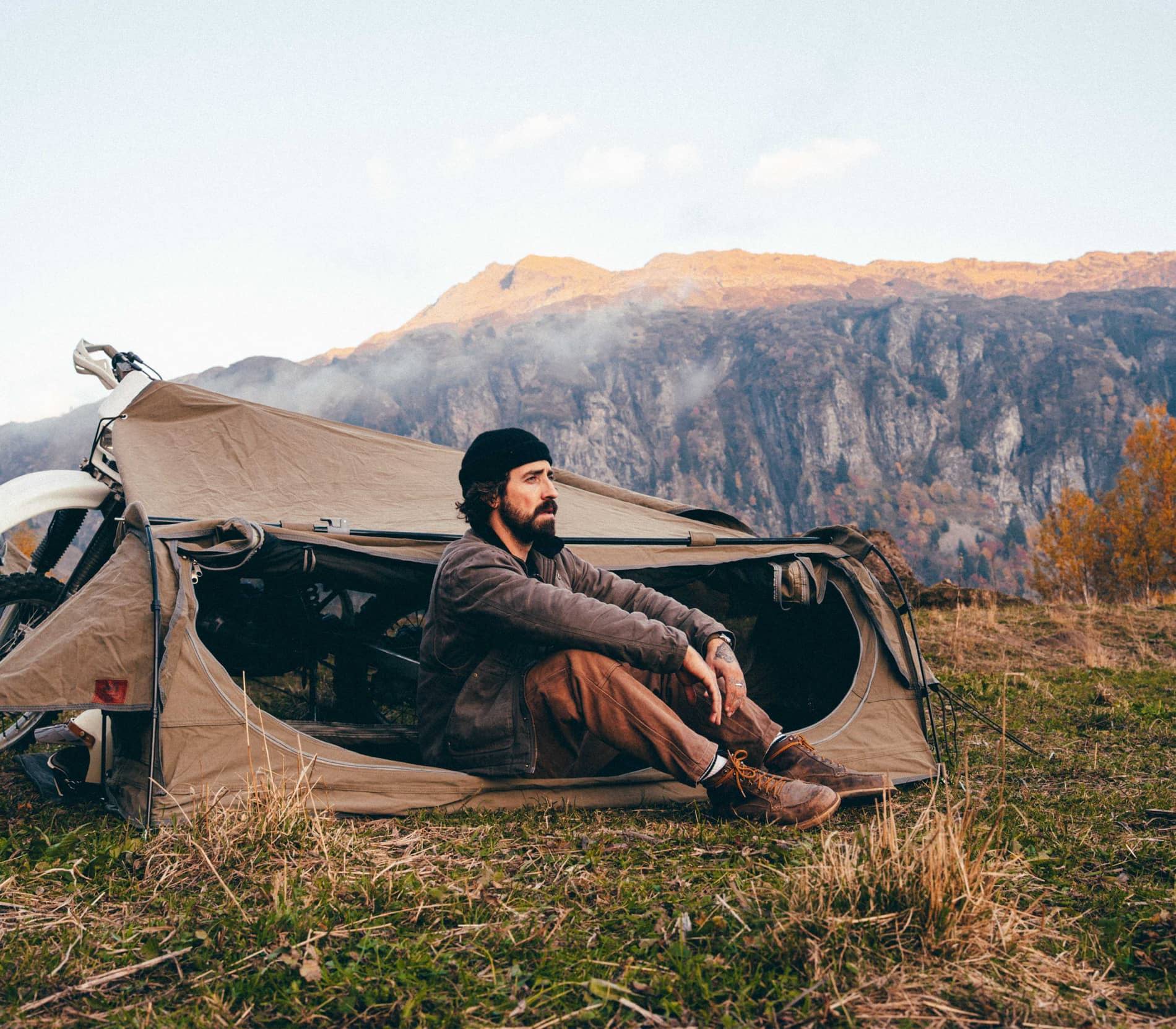 Wingman of the Road motorcycle camping system beside a rider in the mountains