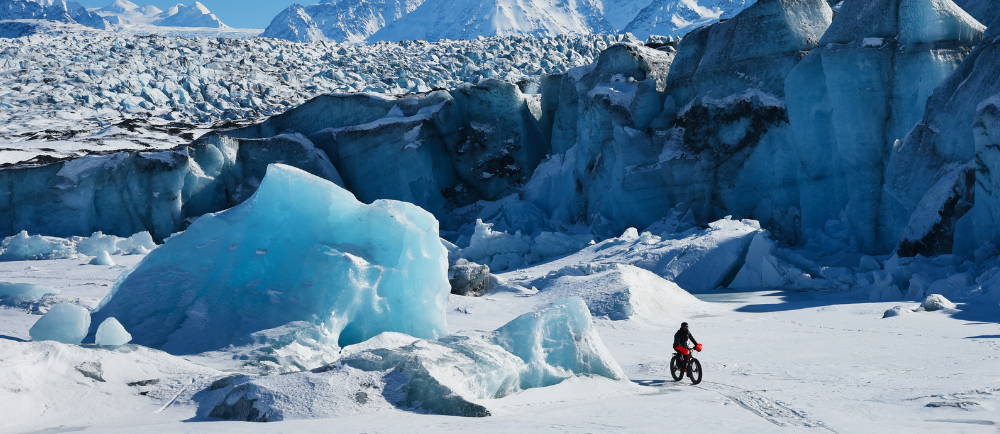 a person riding an electric bike in snowy mountains in Alaska