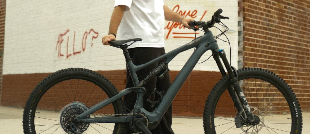 man holding up a full suspension bike