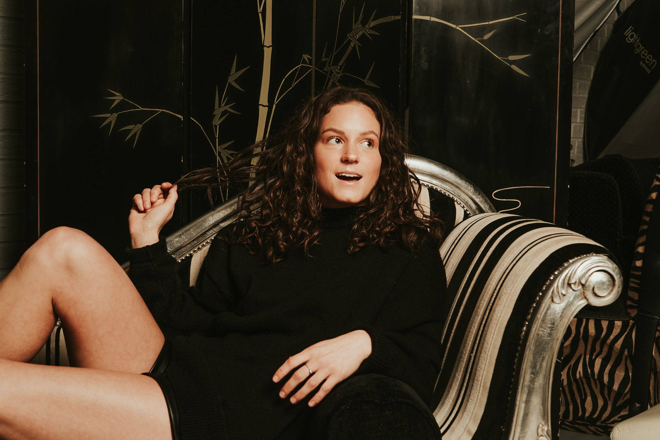 Image of a woman with a wavy hair sitting on the couch