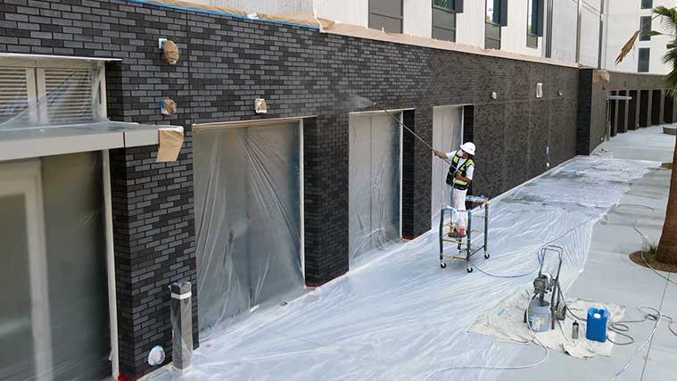 applying anti-graffiti coating on brick facade