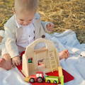 Toddler playing with the Montessori Traveling Farm toy.