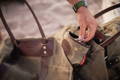 an accessory bag filled with kindling sitting on a firewood sling on the beach