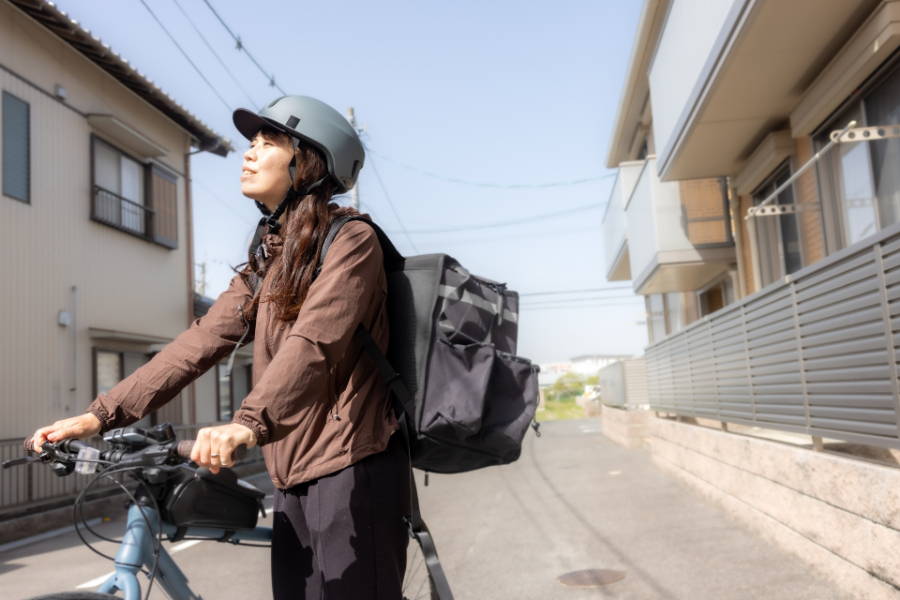 ヘルメットを着用する配達員の女性