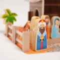 Close up on a wooden apostle featured in the Montessori Nativity Scene set, with other figurines and barn visible in the background.