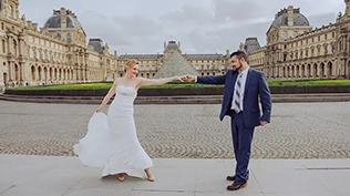 Un moment enchanteur de deux jeunes mariés se tenant en face du Louvre, avec leur robe blanche et leur costume bleu.