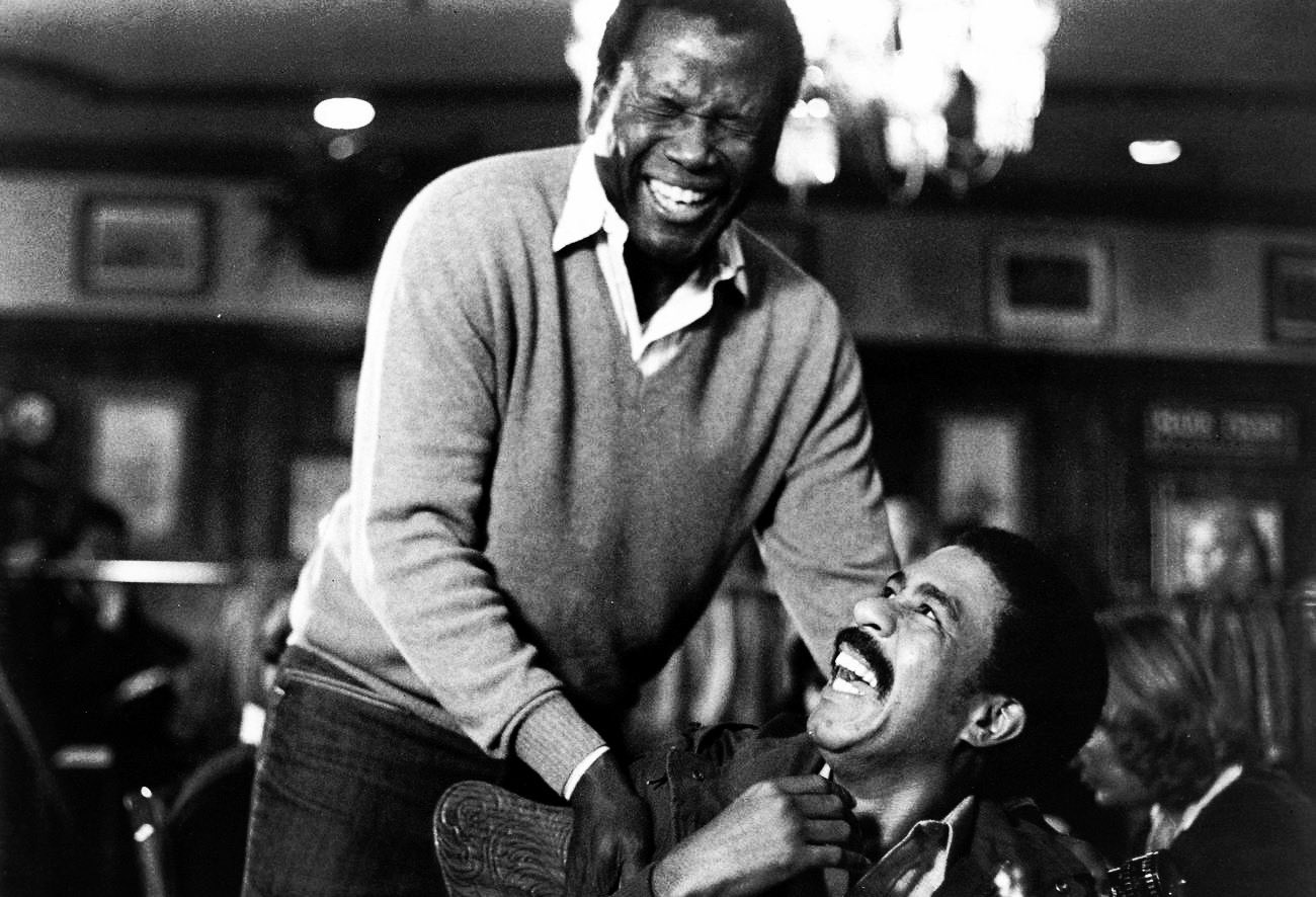 Sidney Poitier and Richard Pryor laughing together.
