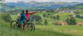 Two People Riding Electric Bike on a Hill