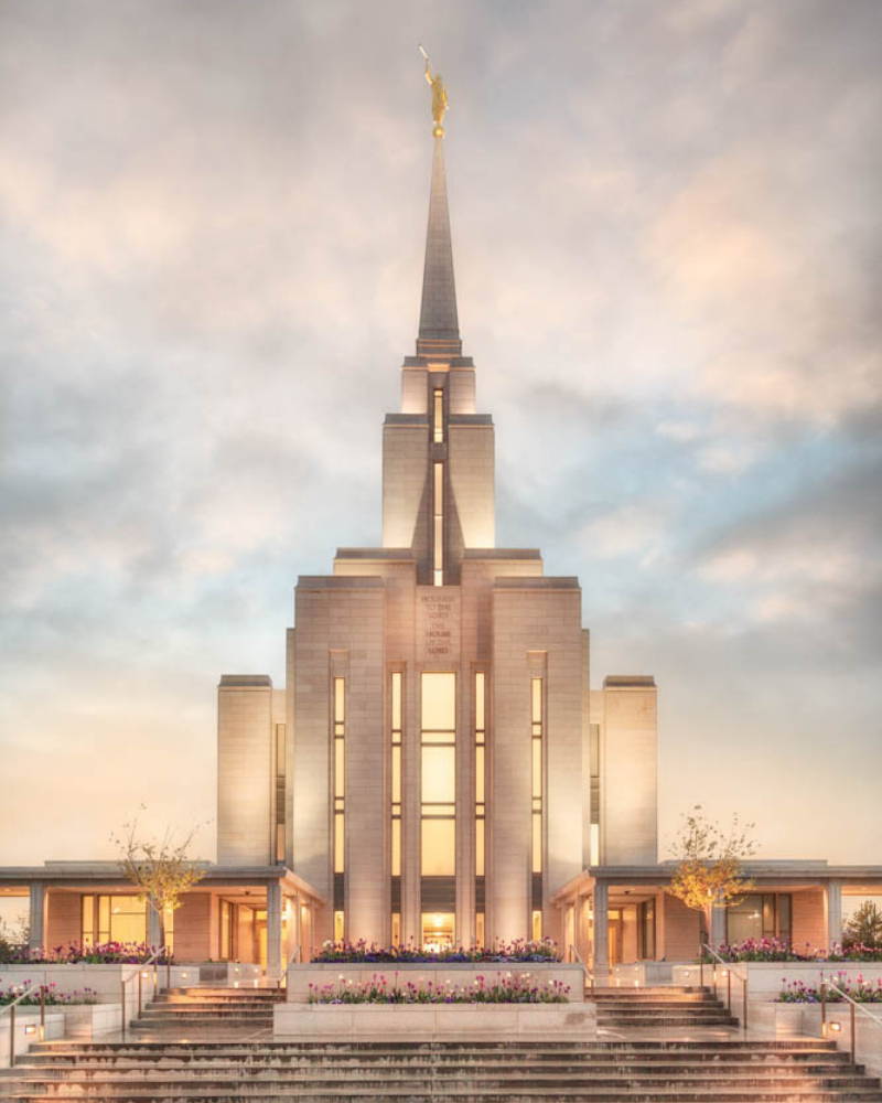 LDS art vertical photo of the Oquirrh Mountain Temple glowing against a cloudy sky.