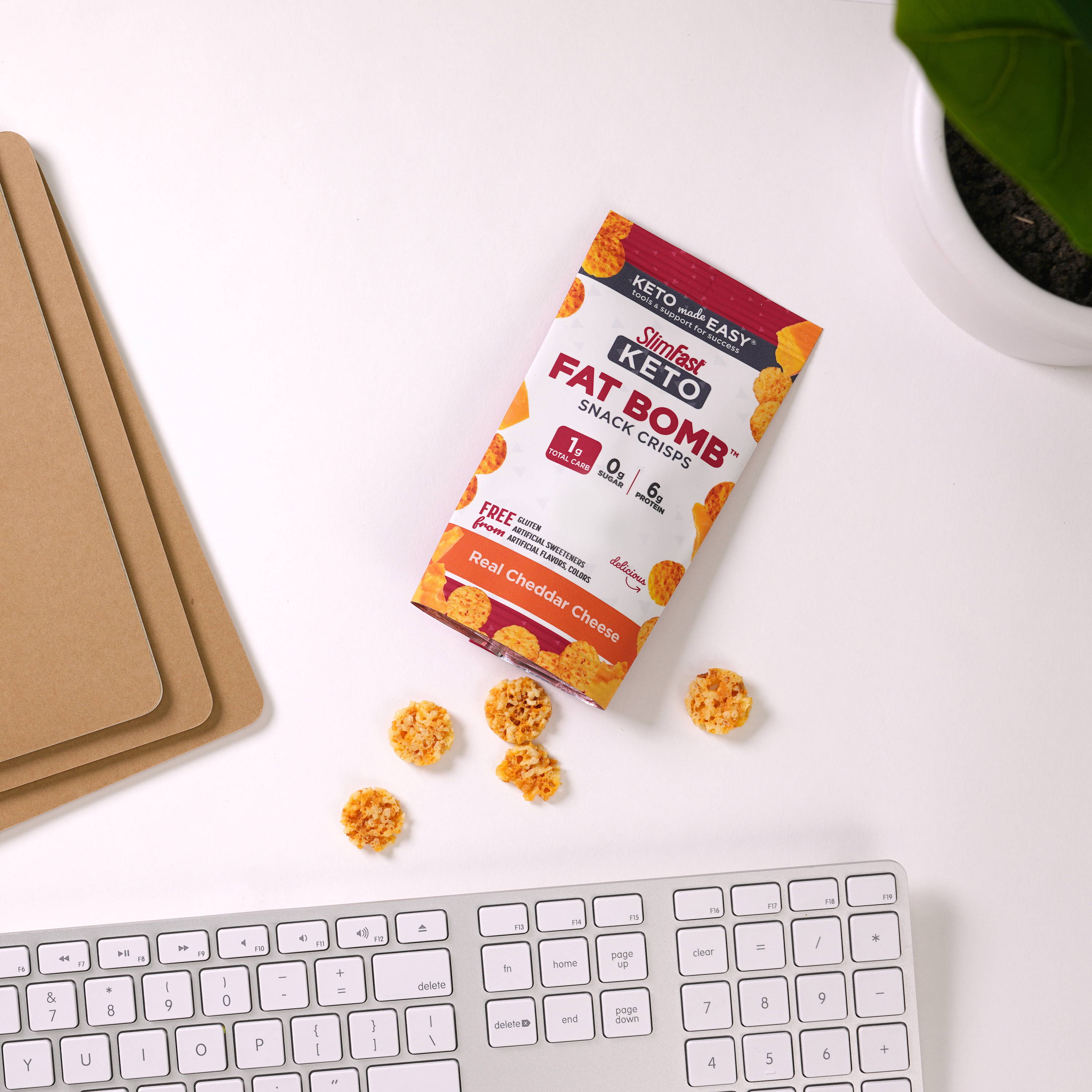 Fat Bomb Snacks Crisps by a keyboard on a desk- lifestyle image
