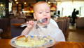 Baby putting a decoration on a birthday cake.