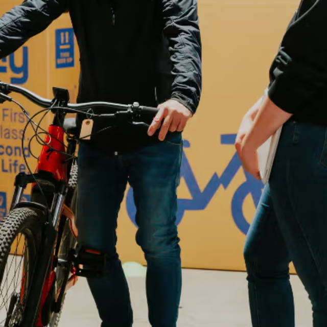 2 men standing next to a specialized electric mountain bike in front of an upway bike box