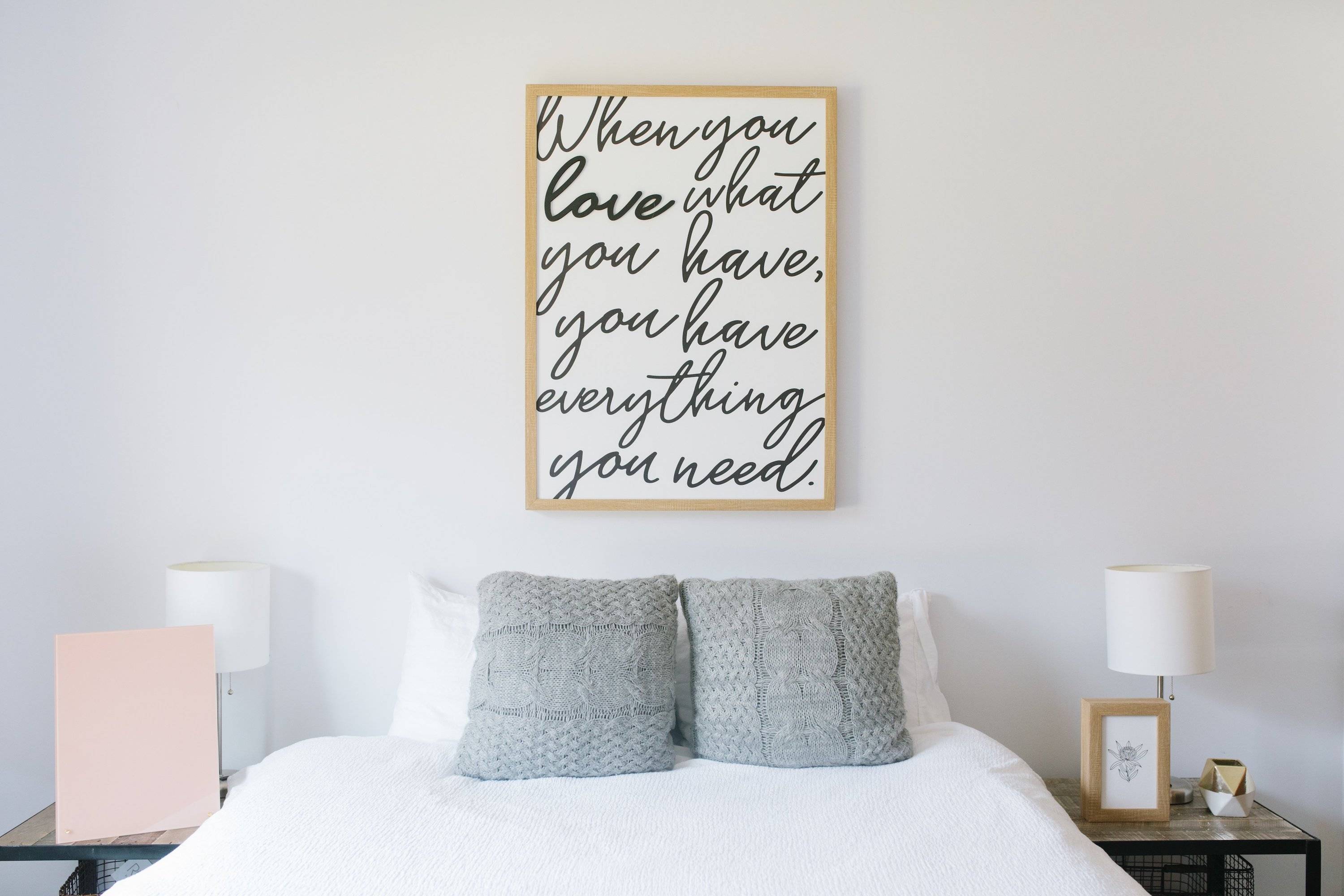 frame hanging on wall above bed