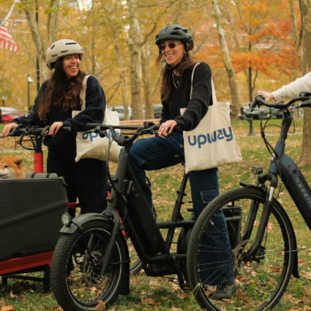two women on electric bikes in a park