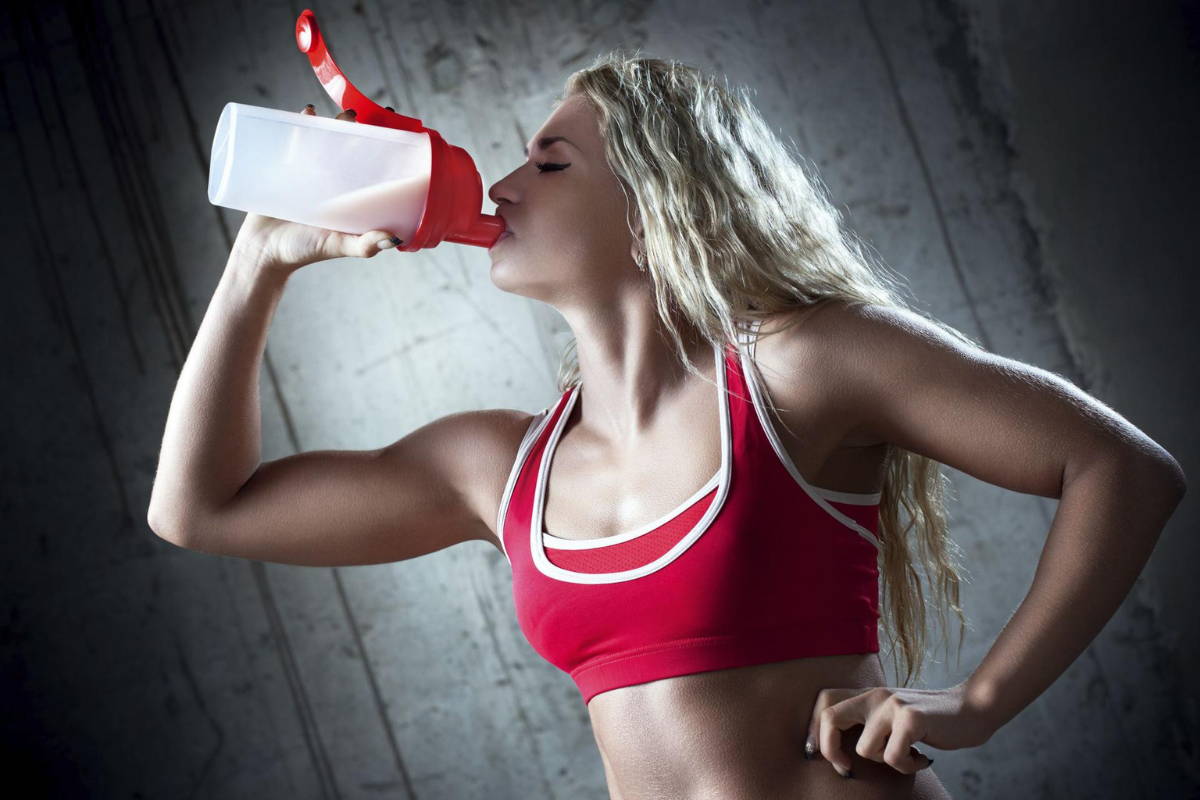 athletes drinking protein in gym before training