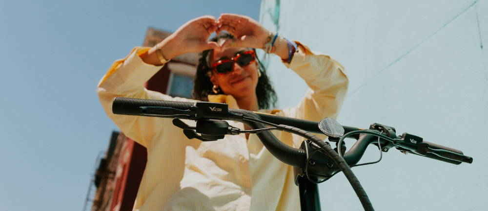 Woman on Specialized Globe Haul electric cargo bike making heart sign