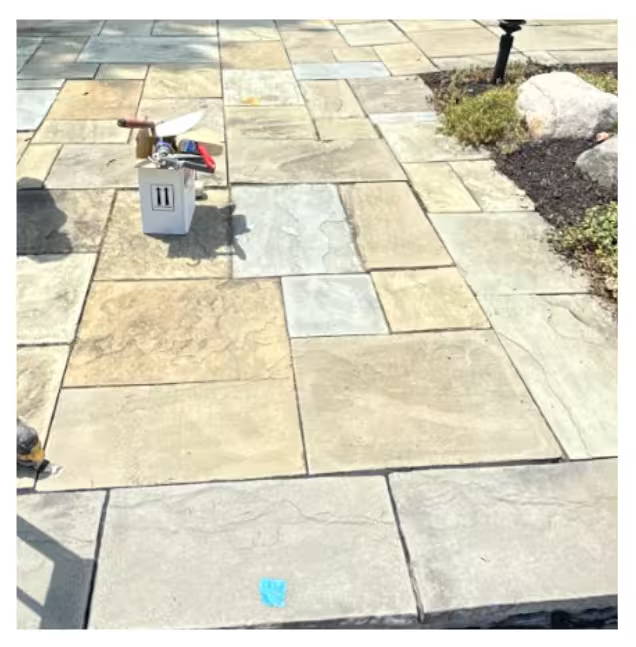 Power washer cleaning a brick-paved surface.