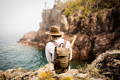 man wearing a geologist pack walking up steps on a rocky hill