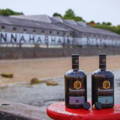 Bouteilles de Single Malt Scotch Whiskies posées sur une bitte d'amarrage de la distillerie Bunnahabhain sur l'île d'Islay dans les Hébrides intérieures d'Ecosse