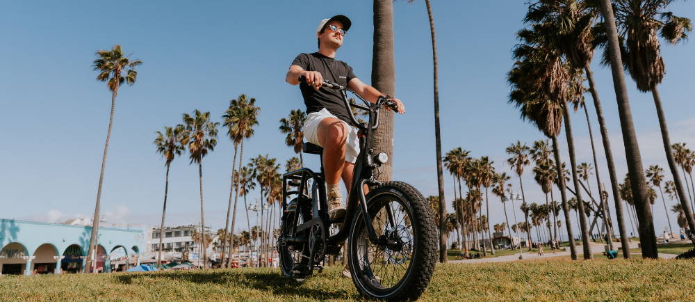 A man riding a bike beachside