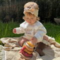 Baby playing with a soft wooden Montessori Little Lion Stacker toy.