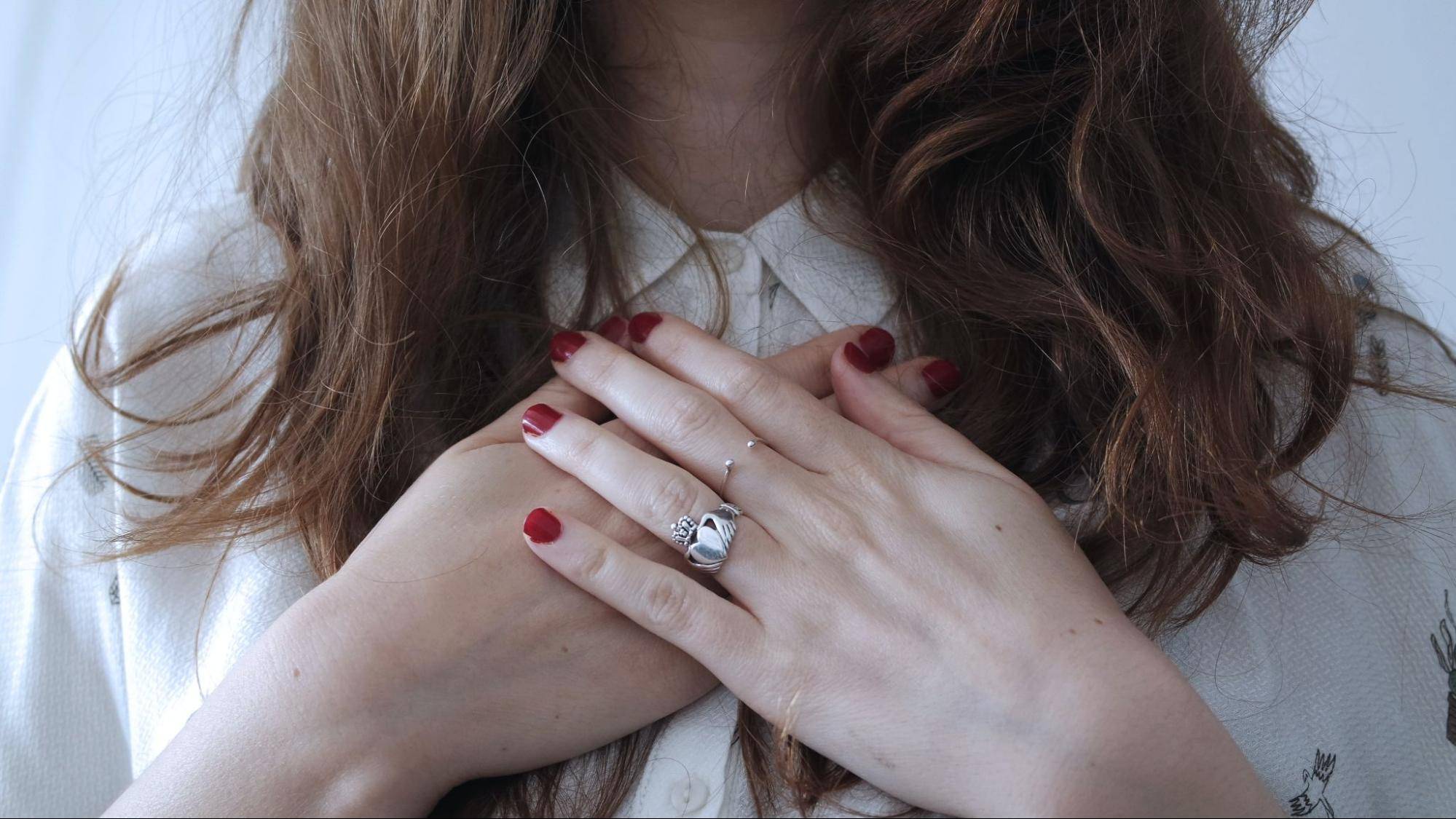 Woman with hands crossed over heart