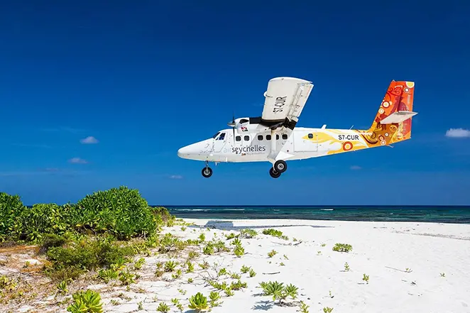 Un hélicoptère atterit sur une plage aux Seychelles