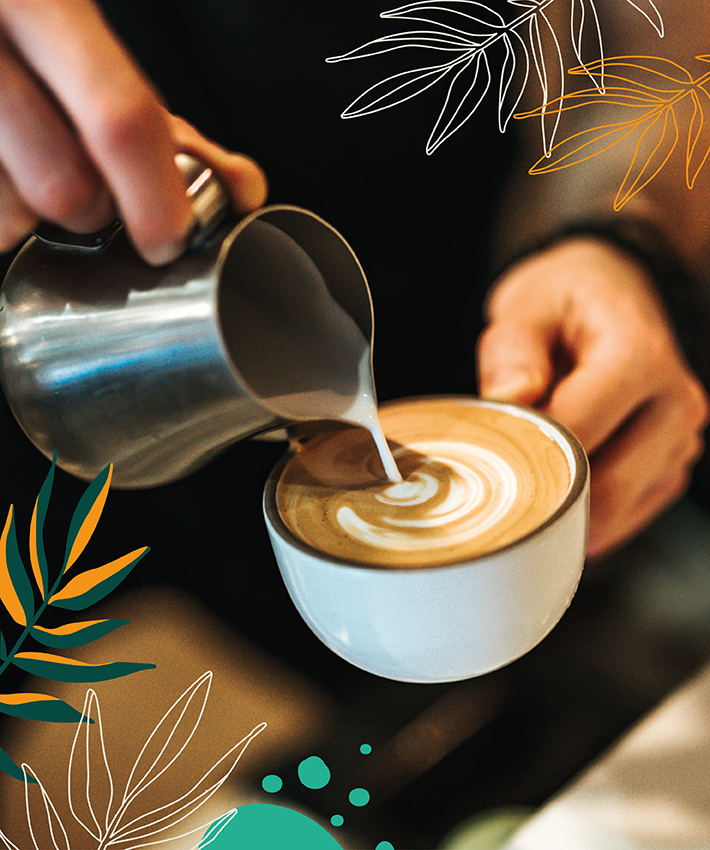 Barista pouring a latte with milk foam art.