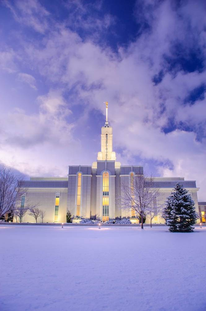 Mount Timpanogos Temple glowing against snowcovered grounds.