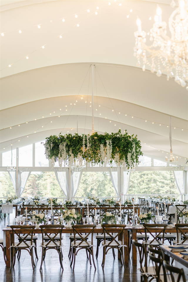tent view of tables and hanging greens 