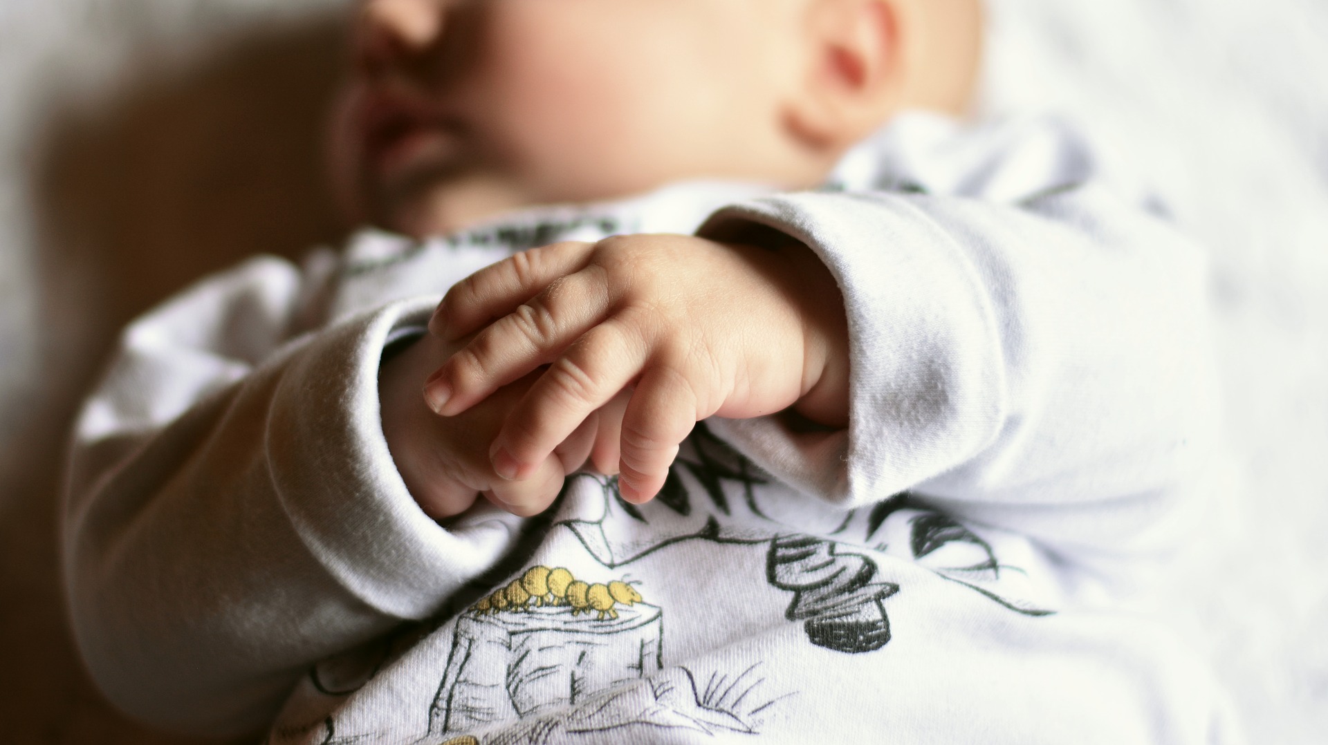 photo of a newborn baby and their hands