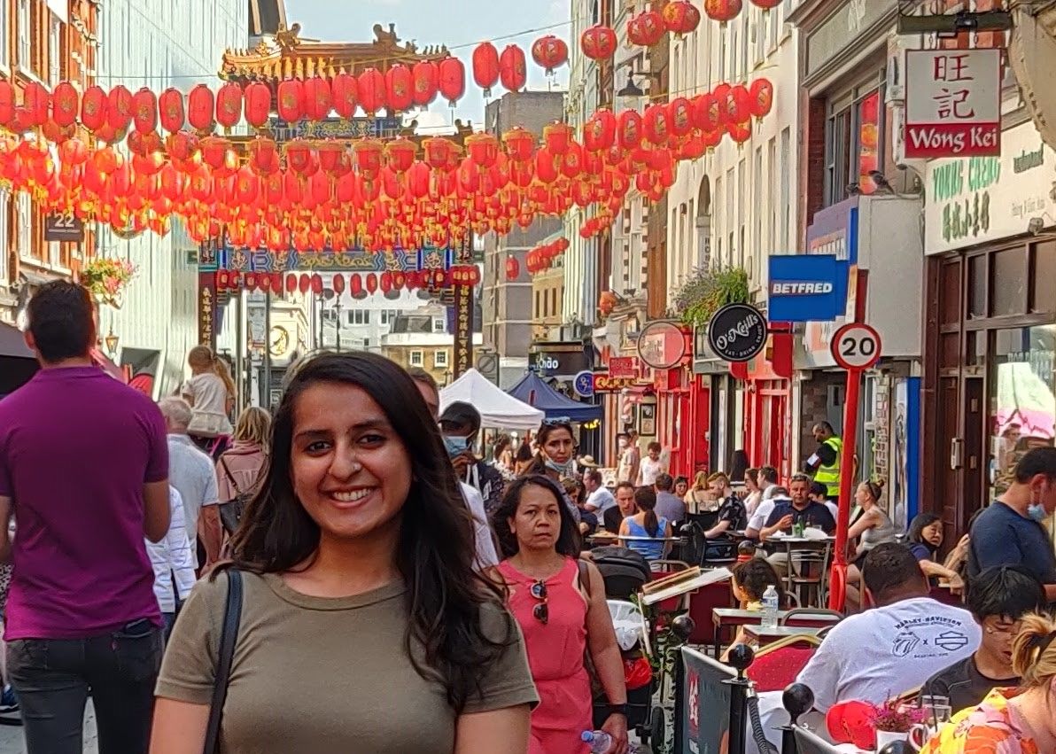 Yashodhra standing smiling in front of the red lanterns in China Town in Soho, London.