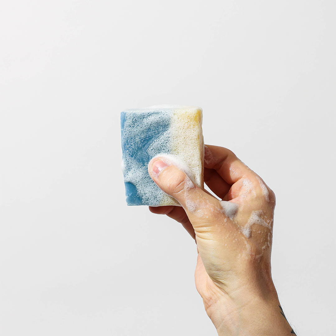 holding up a bar of grondyke soap to show smooth texture
