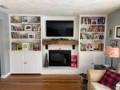 Custom wall unit, built with cabinets on bottom and adjustable shelving on top. Designed to fit around mantle.