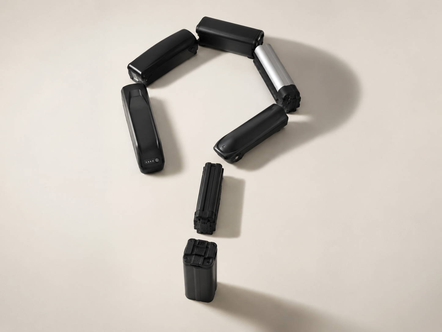 E-bike accu’s in de vorm van een vraagteken om de levensduur en laadcycli van fietsaccu’s uit te beelden.