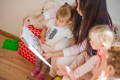 Parent reading Montessori picture books with toddlers during shared reading time at home